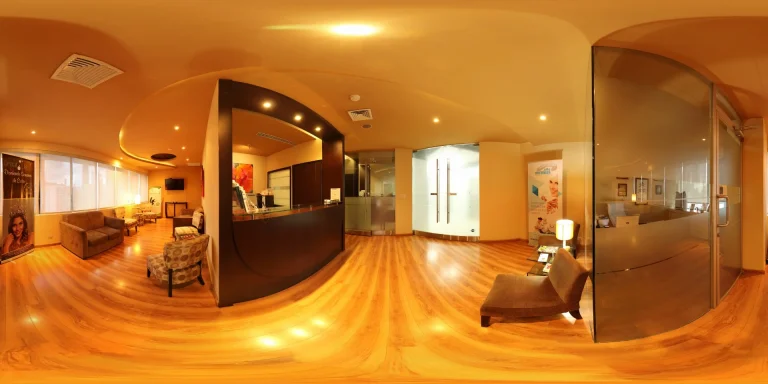 Sala de espera de la clínica dental del Dr. Virgilio Castillero en Panamá, con diseño moderno, iluminación cálida y ambiente confortable para los pacientes.